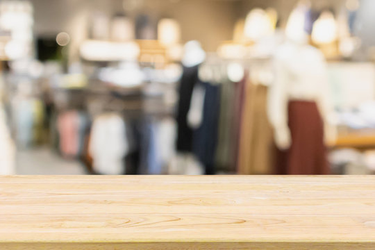 Empty Wood Table With Woman Fashionable Boutique Clothing Store Window Display In Shopping Mall