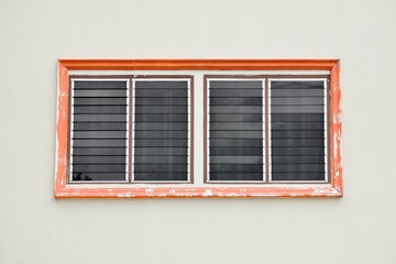 orange antique glass window on white cement wall