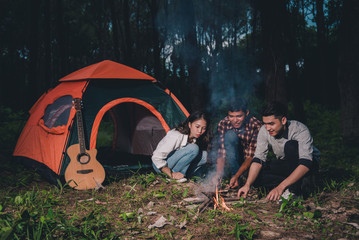 Group of friends are happy enjoying drunk and talking near a tent stay the night, they enjoy relaxing camp in the jungle vacation holidays concept.