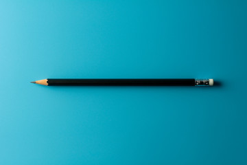 Black pencil on blue paper background. - Business concept.