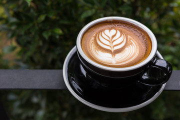 A beautiful cup of Latte art coffee in garden, Green view