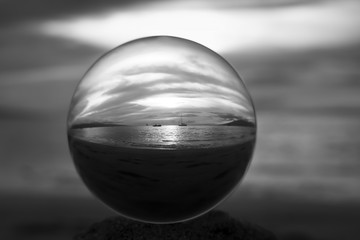 Black and White Sunset Light Glowing over Ocean Captured in Ball with Boats