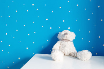 white baby bear toy on the table in nursery