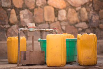 Jerrycans and buckets next to a tap to collect water in Nyamirambo, a semi-rural part of Kigali,...