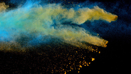 Explosion of coloured powder on black background.