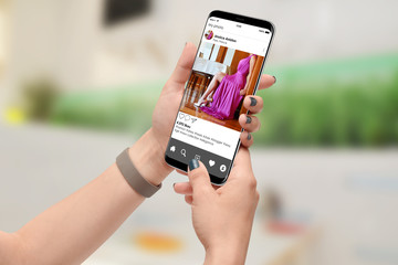Girl looking at publicly shared photo on social network on her smartphone. Girl promoting her new dress on social media app.