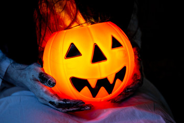 Illumination halloween pumpkin with a monster in white dress close up.