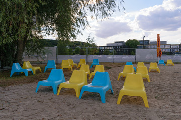 Blue and yellow plastic chairs in the beach