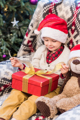 cute happy little boy opening christmas present