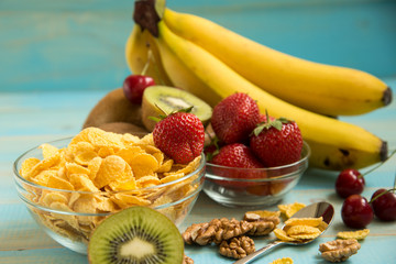Tasty cornflakes in glass bow with walnut and strawberries,