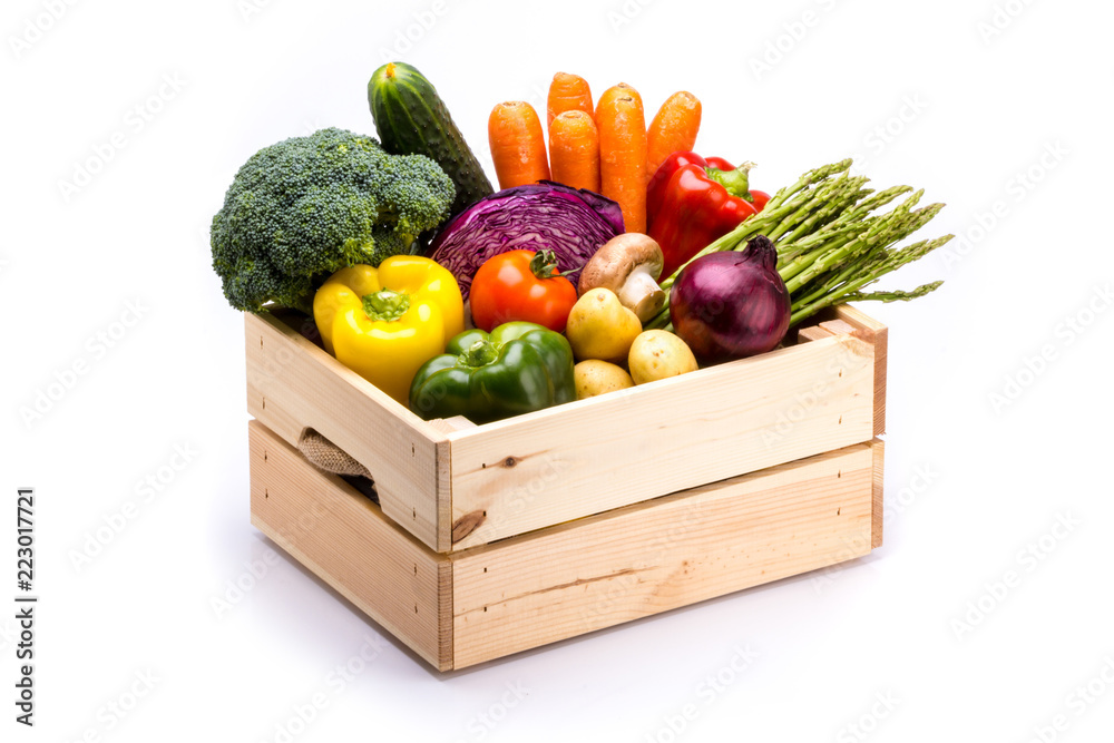 Wall mural Pine box full of colorful fresh vegetables on a white background