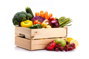 Kiefernkiste voller buntem frischem Gemüse und Obst auf weißem Hintergrund