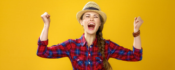 happy young woman grower on yellow background rejoicing