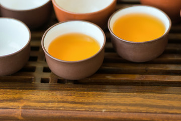 Freshly brewed tea in ceramic cups pot utensils on wooden bamboo dripping tray. Chinese Japanese ceremony. Lifestyle local culture. Wellness balance. Poster banner with copy space