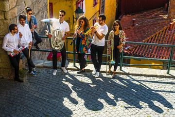 Obraz premium Group of musicians (Jazz band) play music in the street of old Porto downtown, Portugal.