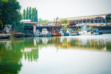 Old pier on the river. Reflections on the water surface.