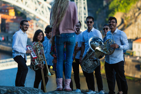 Girl photographer shoots the performance of the jazz band in outdoor.