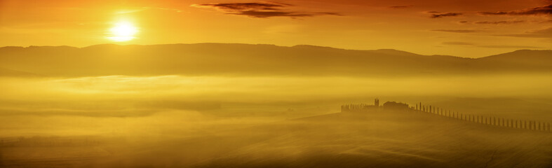 Fototapeta na wymiar Idyllic view, foggy Tuscan hills in light of the rising sun