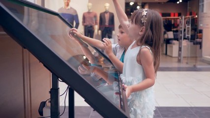 modern technologies at mall, small kids friends use interactive touchscreen display For search information about location of shop