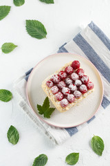 Napoleon cake with raspberries on a white table