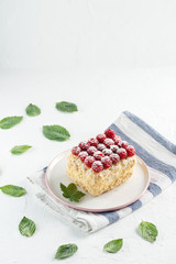 Napoleon cake with raspberries on a white table