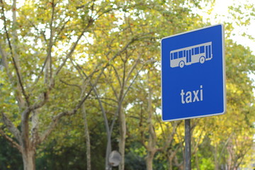 Editorial usage. taxi street sign in Barcelona on trees background , Spain, august 2018 