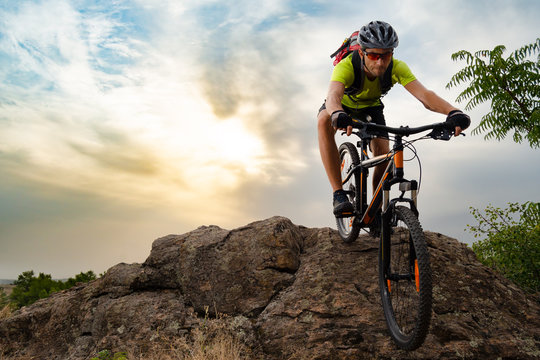 Cyclist Riding the Bike on Autumn Rocky Trail at Sunset. Extreme Sport and Enduro Biking Concept.