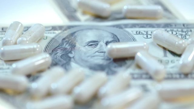 Pharmaceutical Business. White Medical Capsules On Dollar Banknote. Medical Drugs Production Business. Pharmaceutical Pills Sales. Health Care Business. Pharmaceutical Drugs On Dollar Money