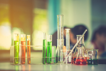 Glassware chemical laboratory on table on blurred student learning and studying laboratory 