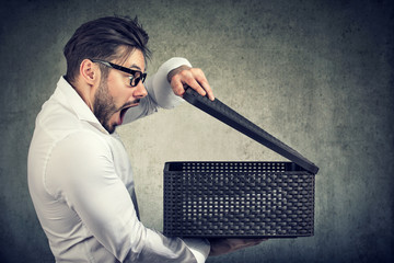 man opening a box with something exciting inside it