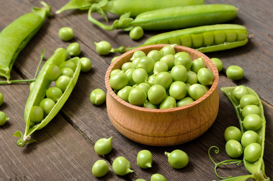 Fresh green peas in wooden bowl