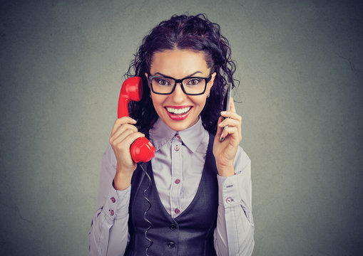 Cheerful woman with smartphone and retro telephone