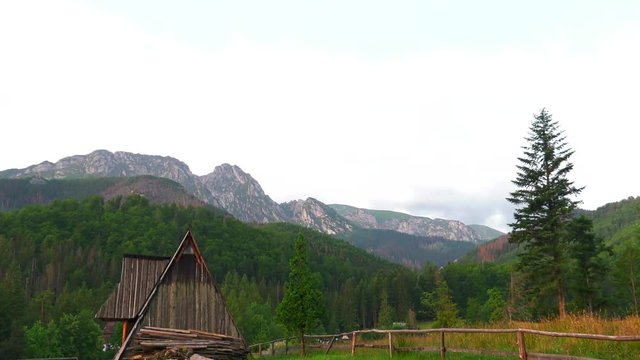 Poland,Zakopane, View of the highlander hut. In the background of mountains TATRY, Clouds. Trees and meadows. Sleeping knight and cross at Giewont. Sunrise. Panning camera, Pan, Closeup