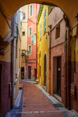 Path between colored houses in Menton, France