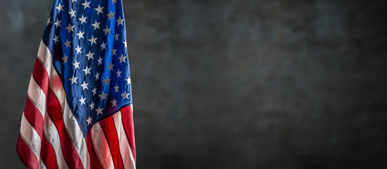 American flag freely hanging against a dark wall
