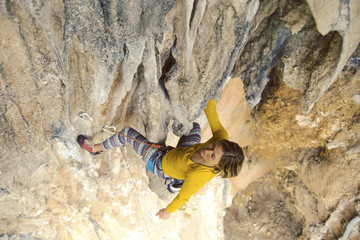Young female rock climber on a cliff face.