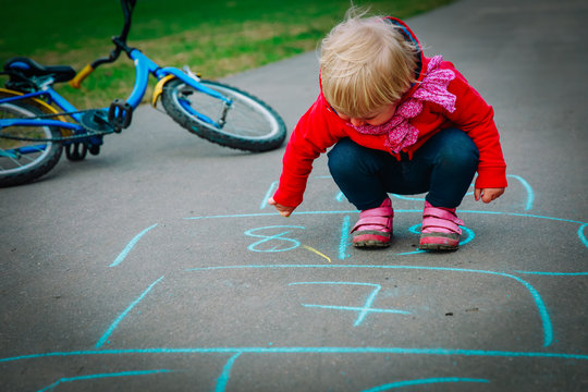 little girl draw play hopscotch on playground