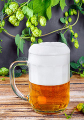 Glass mug of cold fresh golden beer on wooden table