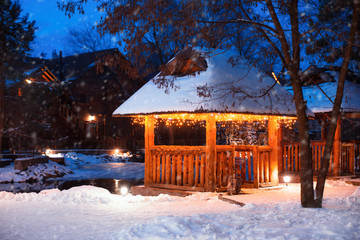 Beautiful gazebo decorated with bright garlands in winter - Powered by Adobe