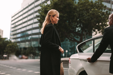 Young businesswoman taking taxi