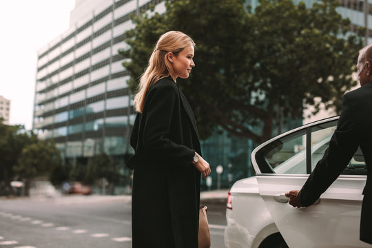 Young businesswoman taking taxi