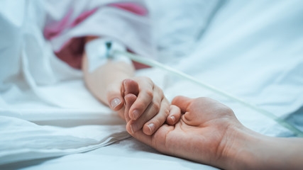 Recovering Little Child Lying in the Hospital Bed Sleeping, Mother Holds Her Hand Comforting. Focus...