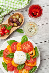 Caprese salad with tomatoes, basil and mozzarella with wine