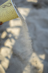 Concept with a paper coffee cup on the beach.