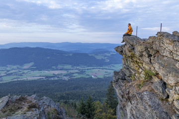 Man sit on a ledge in the Bavarian Forest.
