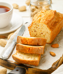 Sliced pound cake with almonds on the cutting Board. Homemade cake with nuts and honey.  Delicacy snack for tea