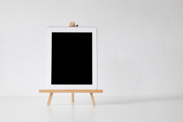 Mockup digital tablet on wooden stand and white isolated background.