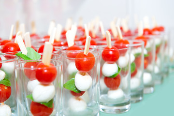 Mini caprese cherry tomatos and mini mozzarella in a glass - Finger food.