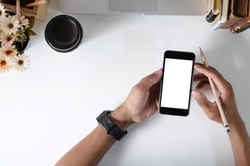 Man holding mockup smartphone on office desk.