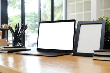 Mockup laptop computer on working office desk with office supplies.